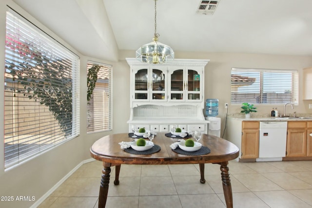 dining room featuring sink, light tile patterned flooring, vaulted ceiling, and a notable chandelier