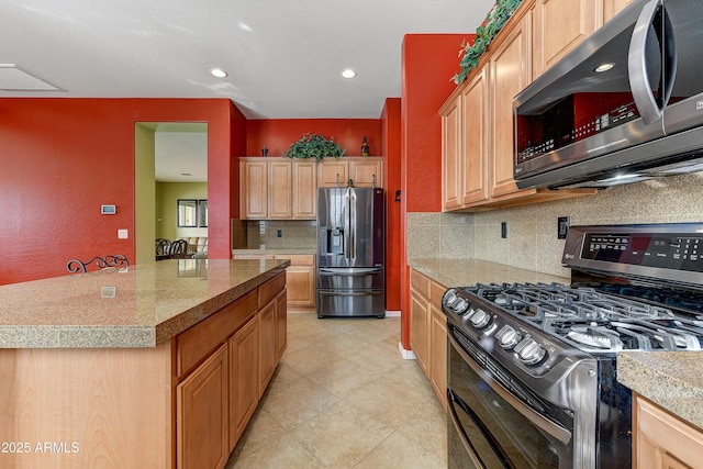 kitchen with stainless steel appliances, a center island, backsplash, and light brown cabinetry