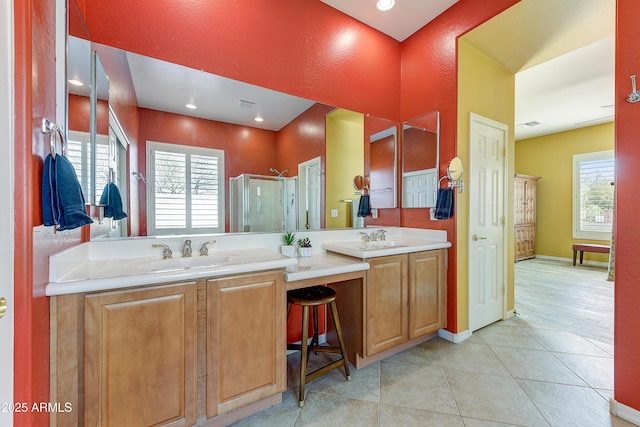 bathroom with tile patterned flooring, an enclosed shower, vanity, and a wealth of natural light