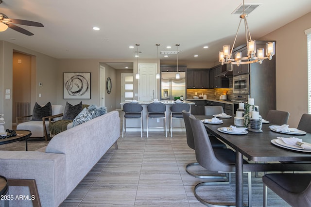 dining room featuring ceiling fan with notable chandelier and light tile patterned floors