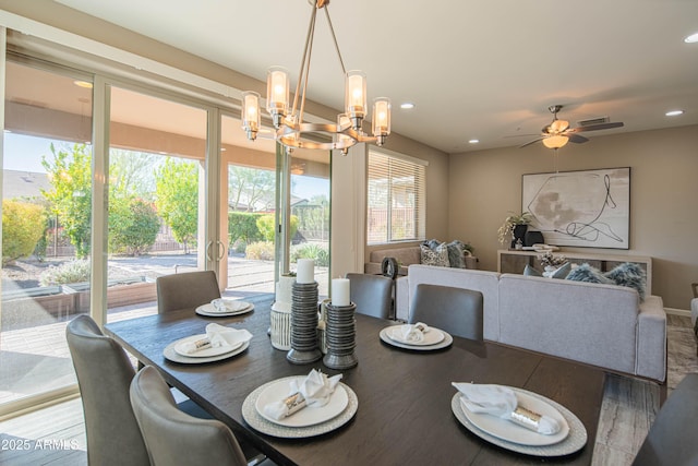 dining area with wood-type flooring, plenty of natural light, and ceiling fan with notable chandelier