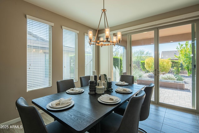 tiled dining room featuring an inviting chandelier