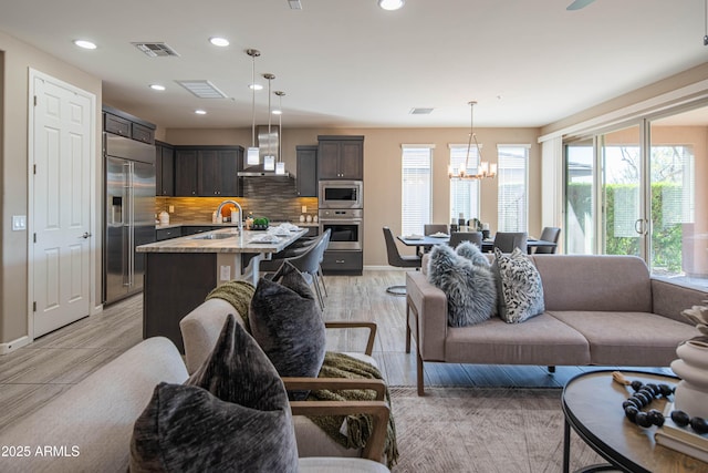 living room with a chandelier, light hardwood / wood-style flooring, and sink