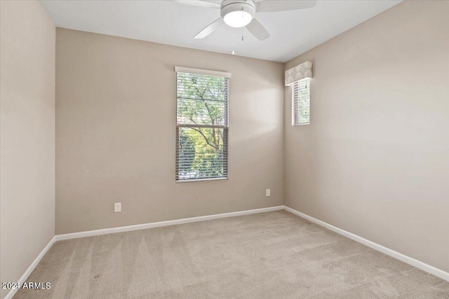 carpeted spare room featuring ceiling fan