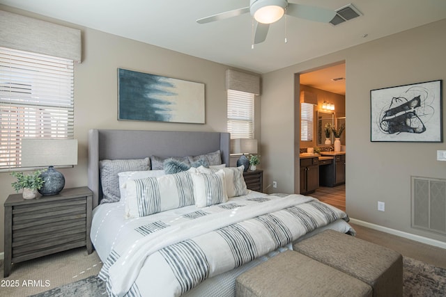 carpeted bedroom with ceiling fan and ensuite bath