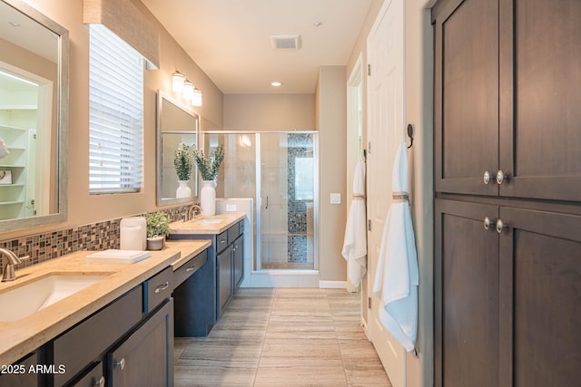 bathroom featuring vanity, tile patterned floors, backsplash, and an enclosed shower