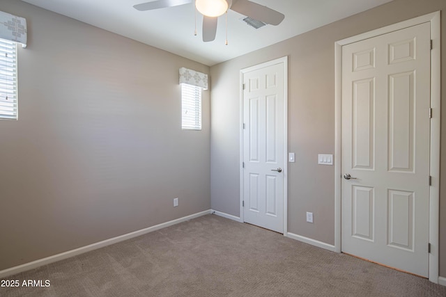 unfurnished bedroom with ceiling fan and light colored carpet