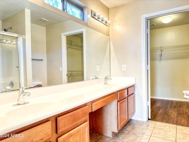 bathroom featuring vanity, tile patterned floors, and walk in shower