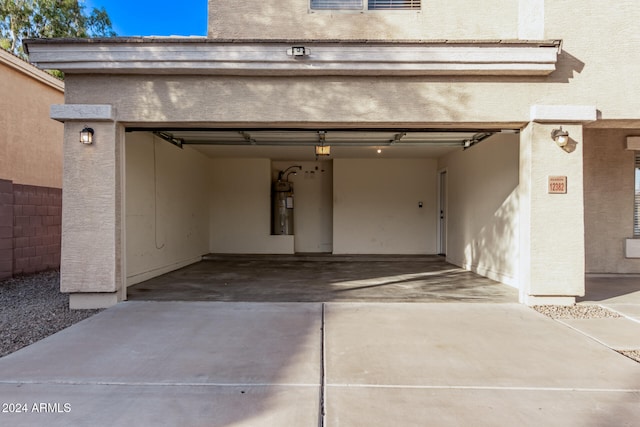 garage featuring secured water heater and a carport