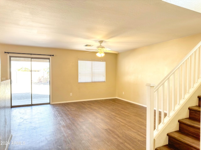 empty room featuring ceiling fan, wood-type flooring, and a textured ceiling