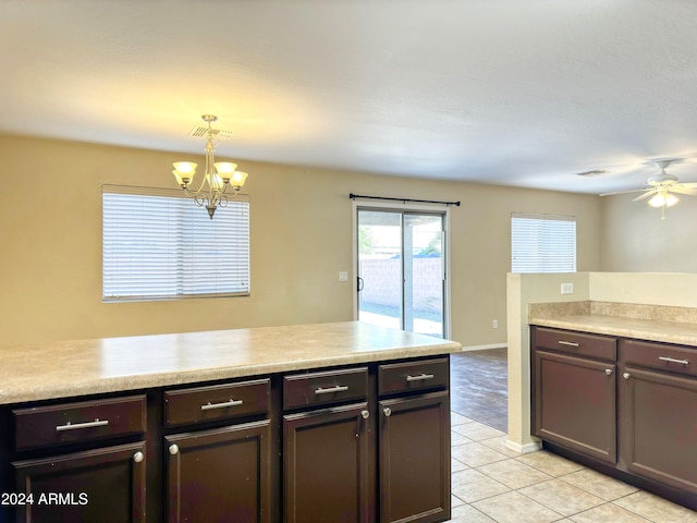 kitchen featuring ceiling fan with notable chandelier, light tile patterned floors, dark brown cabinetry, and decorative light fixtures