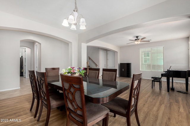 1876 E Azalea Ct, Gilbert, AZ 85298 - dining area featuring arched walkways, a chandelier, a ceiling fan, stairway, and baseboards