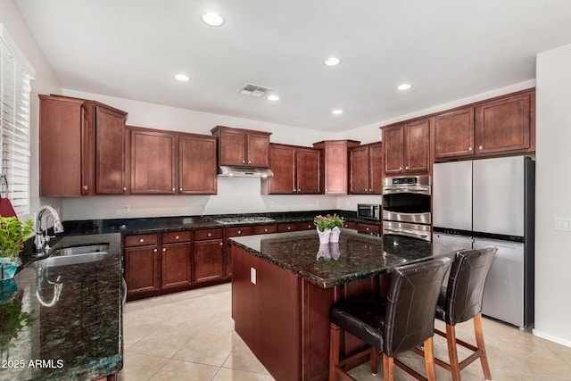 1876 E Azalea Ct, Gilbert, AZ 85298 - kitchen with stainless steel appliances, a sink, a center island, light tile patterned floors, and dark stone countertops