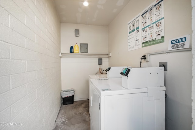 clothes washing area featuring electric panel and washer and clothes dryer