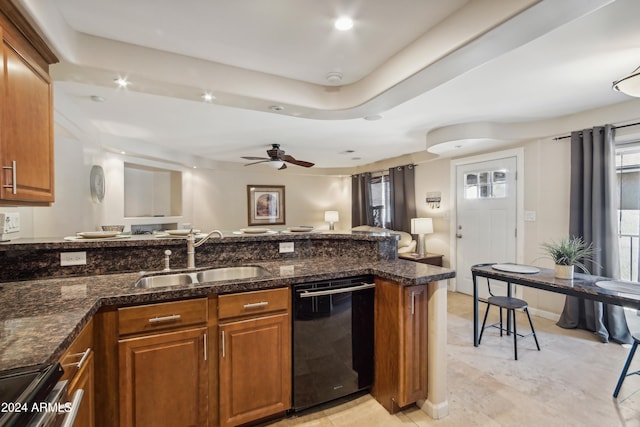 kitchen featuring dark stone counters, dishwasher, sink, stainless steel stove, and ceiling fan