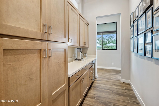 bar featuring hardwood / wood-style flooring, light brown cabinetry, and beverage cooler