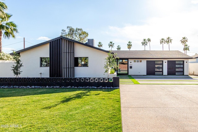 view of front facade featuring concrete driveway, a front lawn, stucco siding, and an attached garage