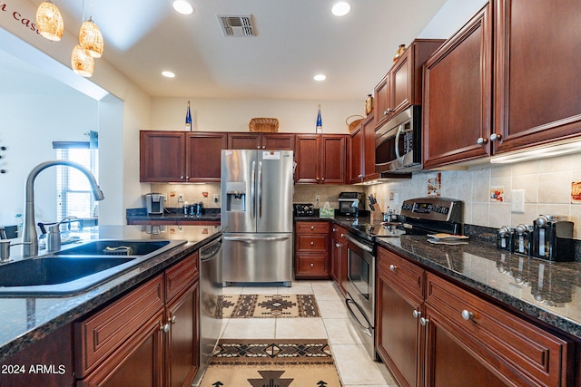 kitchen with pendant lighting, sink, stainless steel appliances, backsplash, and light tile patterned floors