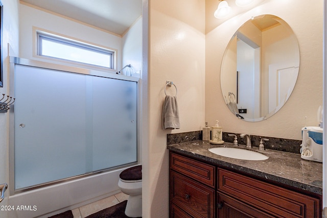 full bathroom with tile patterned floors, vanity, toilet, and combined bath / shower with glass door