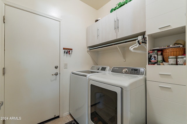 laundry room featuring independent washer and dryer, light tile patterned flooring, and cabinets