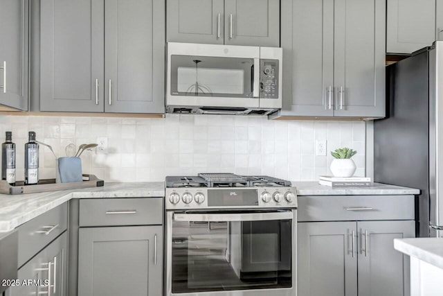 kitchen with backsplash, appliances with stainless steel finishes, and gray cabinets