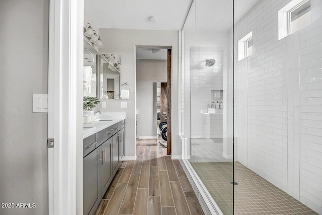 bathroom featuring a tile shower and vanity