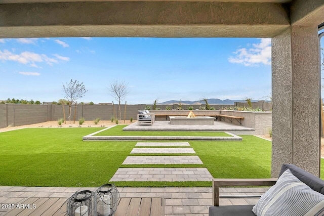 view of yard with a mountain view, a fire pit, and a patio