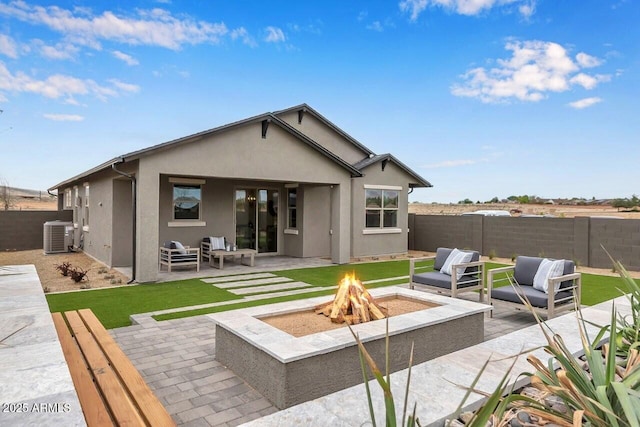 rear view of property featuring central AC unit, a patio, and an outdoor living space with a fire pit