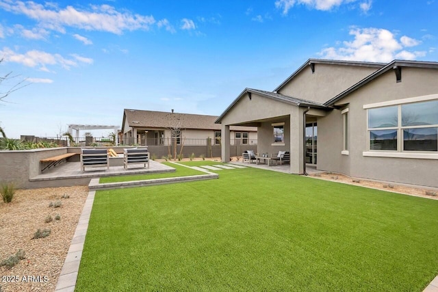 back of house with a lawn and a patio