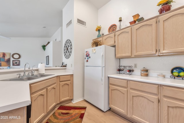 kitchen featuring white refrigerator, sink, light brown cabinetry, and light hardwood / wood-style flooring