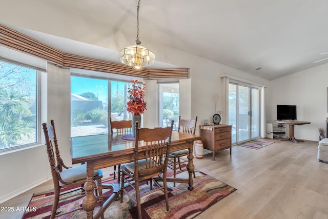 dining area with plenty of natural light, light hardwood / wood-style flooring, and a notable chandelier