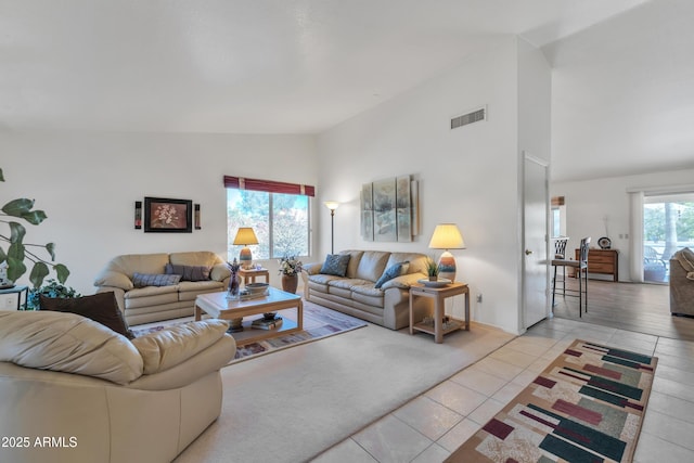 living room with light tile patterned floors and high vaulted ceiling