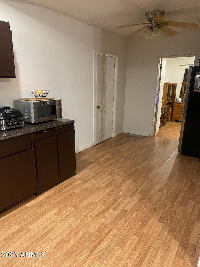 kitchen with light hardwood / wood-style flooring, ceiling fan, dark brown cabinets, and fridge