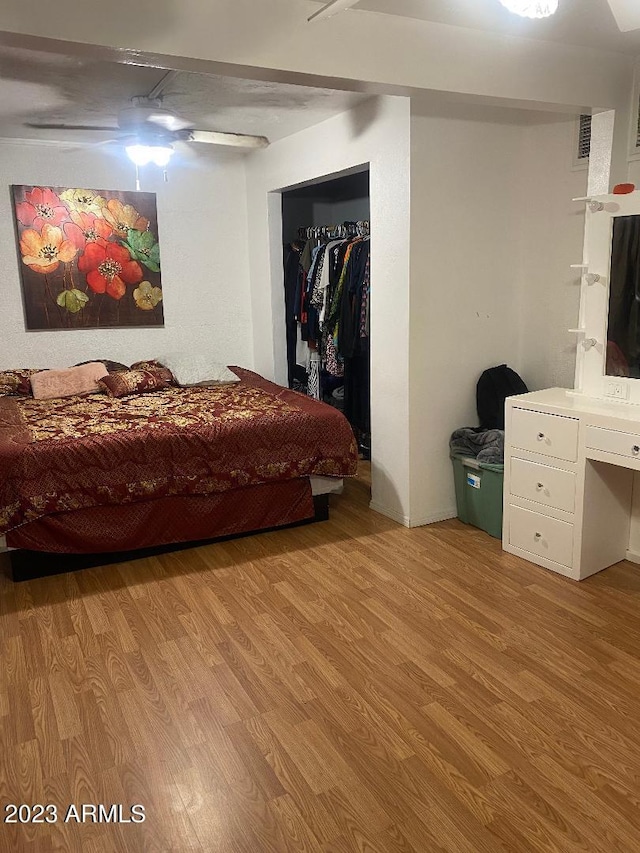 bedroom with ceiling fan, light hardwood / wood-style flooring, and a closet