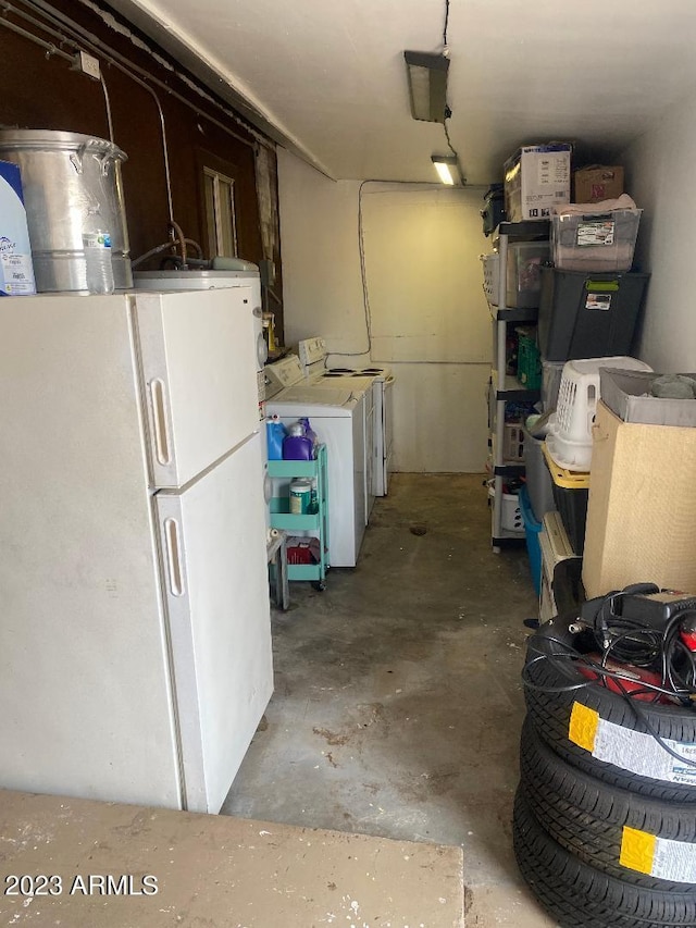 interior space with washer and clothes dryer and white refrigerator