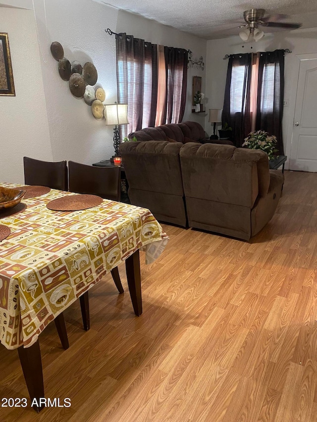 dining area featuring a textured ceiling, light hardwood / wood-style floors, and ceiling fan