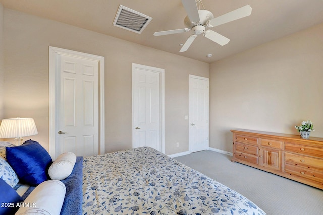 carpeted bedroom featuring a ceiling fan, visible vents, and baseboards