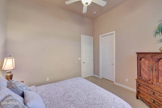 bedroom with light carpet, ceiling fan, and baseboards