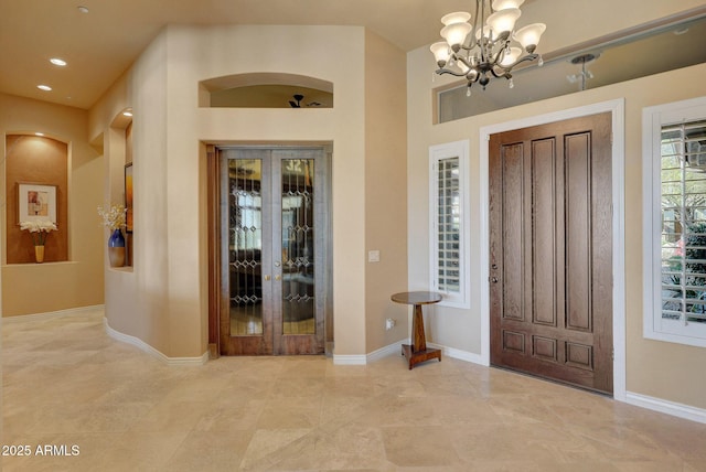 entryway featuring recessed lighting, a notable chandelier, and baseboards