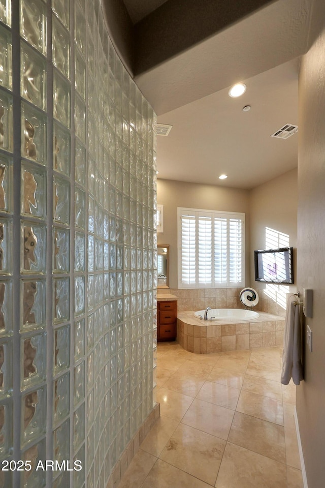 full bathroom featuring walk in shower, a garden tub, visible vents, and tile patterned floors