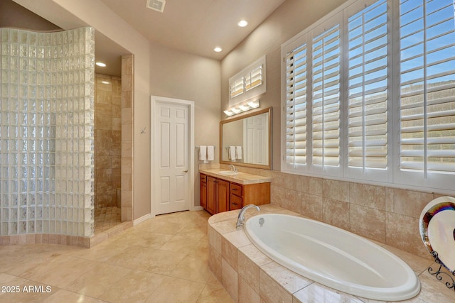 full bathroom with tile patterned flooring, walk in shower, vanity, a bath, and recessed lighting