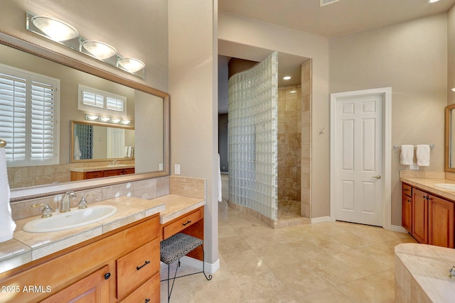 full bath featuring walk in shower, two vanities, a sink, and baseboards