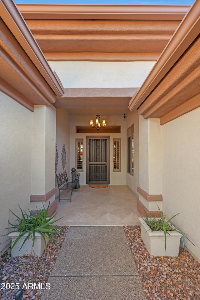 view of exterior entry featuring a patio area and stucco siding