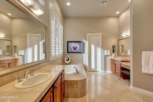 bathroom with a bath, visible vents, and a sink