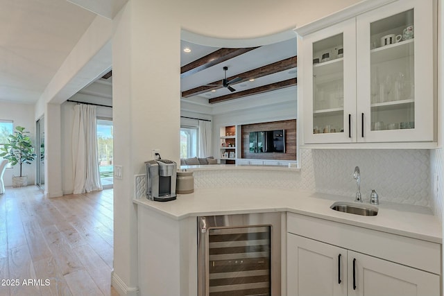 kitchen featuring tasteful backsplash, sink, beamed ceiling, white cabinets, and wine cooler