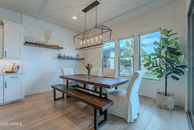 dining room with plenty of natural light, light wood-type flooring, and a chandelier