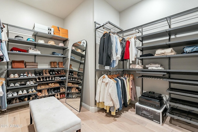 walk in closet with light hardwood / wood-style floors