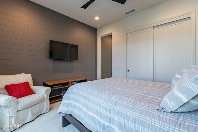 bedroom with ceiling fan, a closet, and light carpet