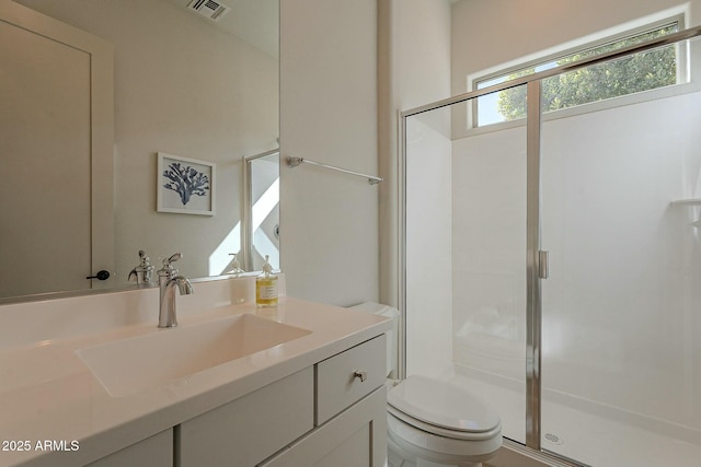 bathroom with walk in shower, vanity, and toilet