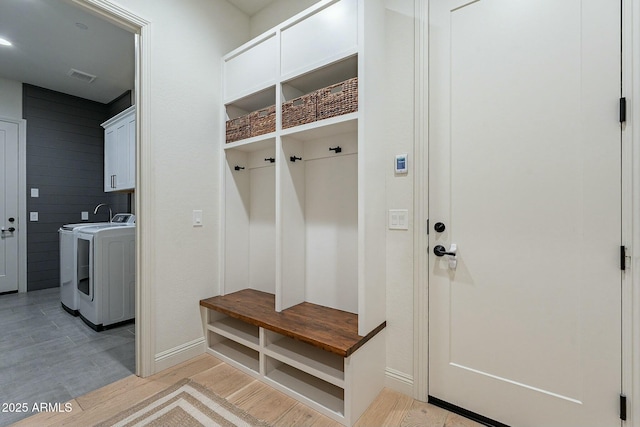 mudroom with light hardwood / wood-style flooring and washer and dryer